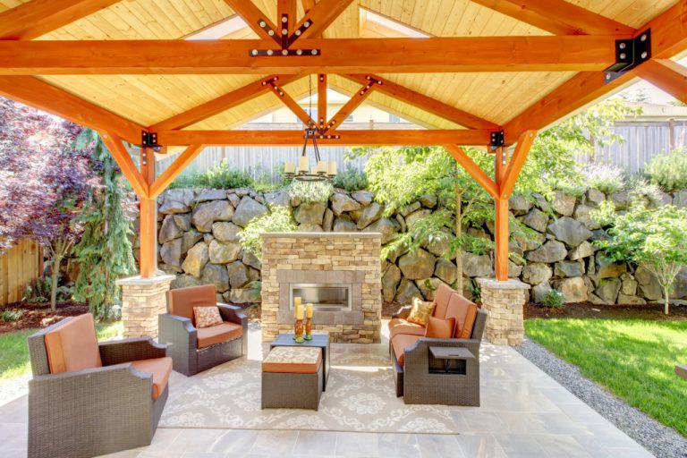 A covered patio with furniture and fireplace